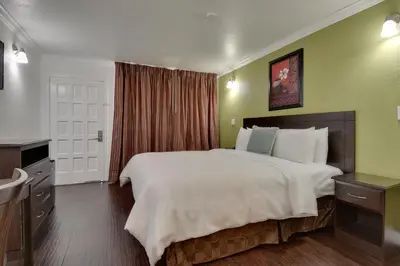 a hotel room with a large bed and a bathroom at Vagabond Inn San Pedro in San Pedro