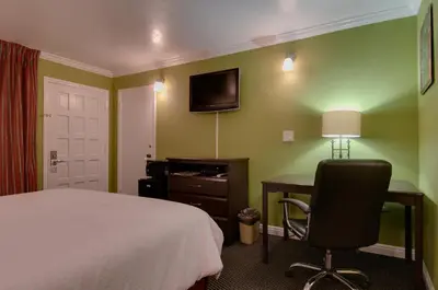 a hotel room with a bed and a desk and a chair at Vagabond Inn San Pedro in San Pedro
