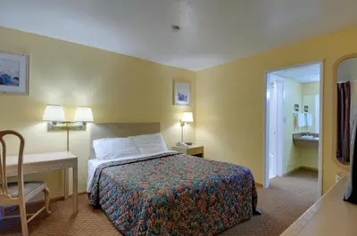 a hotel room with a bed and a desk and a bedroom at Vagabond Inn San Pedro in San Pedro