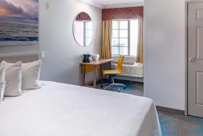 a hotel room with a bed and a desk and a window at Days Inn by Wyndham Santa Monica in Los Angeles