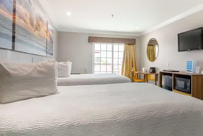 a hotel room with two beds and a television at Days Inn by Wyndham Santa Monica in Los Angeles