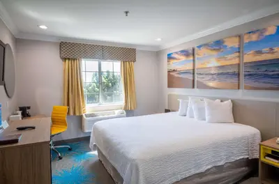 a hotel room with a bed and a desk and a window at Days Inn by Wyndham Santa Monica in Los Angeles