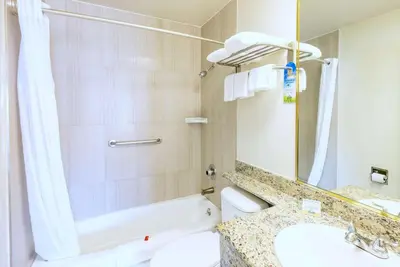 a bathroom with a sink and a toilet and a mirror at Days Inn by Wyndham Santa Monica in Los Angeles