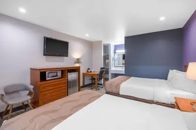 a hotel room with two beds and a flat screen tv at Quality Inn Near Hollywood Walk of Fame in Los Angeles