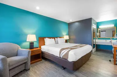 a bedroom with a bed and a couch and a chair at Quality Inn Near Hollywood Walk of Fame in Los Angeles