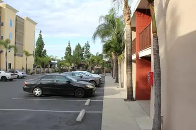 a row of cars parked in a parking lot at Budget Inn Anaheim near Disneyland Drive in Anaheim
