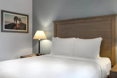a bedroom with a large white bed and a lamp at Club Wyndham Dolphin's Cove in Anaheim