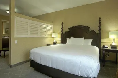 a bedroom with a large white bed and two lamps at Azure Hotel&Suites Ontario Trademark Collection by Wyndham in Ontario