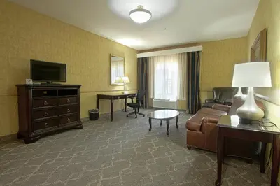 a hotel room with a couch and a television and a desk at Azure Hotel&Suites Ontario Trademark Collection by Wyndham in Ontario