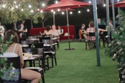 a group of people sitting at tables in an outdoor restaurant at Hollywood Historic Hotel in Los Angeles