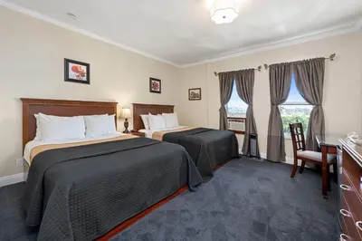 a hotel room with two beds and a desk at Hollywood Historic Hotel in Los Angeles
