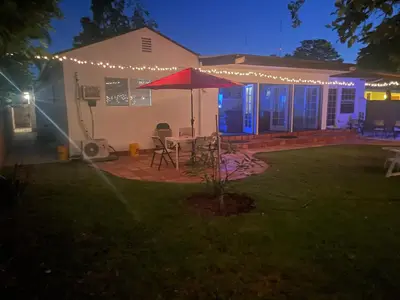 a patio with a table with an umbrella and lights at The Village in North Hollywood