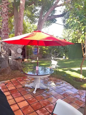 a table with a red umbrella on a patio at The Village in North Hollywood