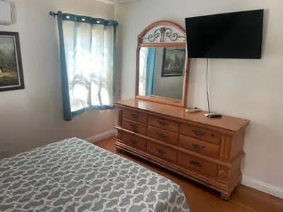 a bedroom with a dresser with a mirror and a television at The Village in North Hollywood