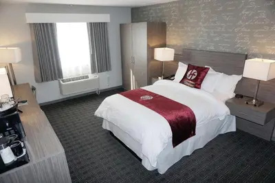 a large hotel room with a large bed and two windows at Hartford Hotel Best Western Signature Collection in Rosemead