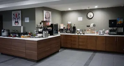 a restaurant with two counters and a clock on the wall at Hartford Hotel Best Western Signature Collection in Rosemead