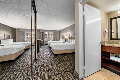 a hotel room with two beds and a mirror at Best Western Los Alamitos Inn & Suites in Los Alamitos