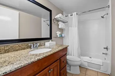 a bathroom with a sink and a toilet and a mirror at Best Western Los Alamitos Inn & Suites in Los Alamitos