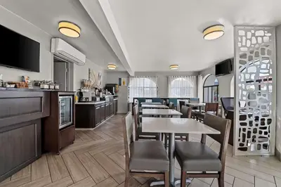 a restaurant with tables and chairs and a bar at Best Western Los Alamitos Inn & Suites in Los Alamitos