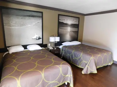 a hotel room with two beds and pictures on the wall at Skyways Hotel in Los Angeles