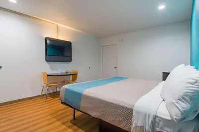 a bedroom with a bed and a desk and a tv at Motel 6-San Bernardino, CA - Downtown in San Bernardino
