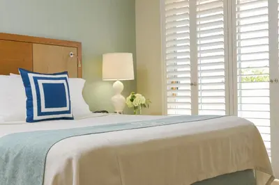 a bedroom with a bed with a blue and white pillow at Gateway Hotel Santa Monica in Los Angeles