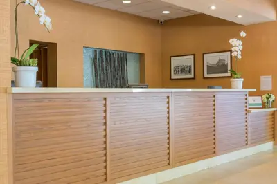 a reception desk in a lobby with wood paneling at Gateway Hotel Santa Monica in Los Angeles