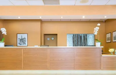 a waiting room with a wooden reception desk at Gateway Hotel Santa Monica in Los Angeles