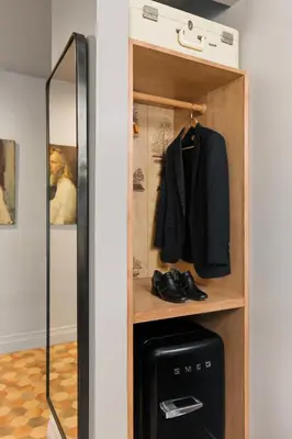 a closet with a black suit and a mirror at Palihotel Westwood Village - West Beverly Hills in Los Angeles