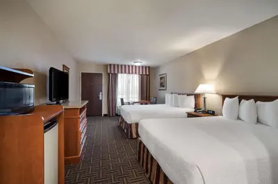 a hotel room with two beds and a flat screen tv at Best Western Norwalk Inn in Norwalk