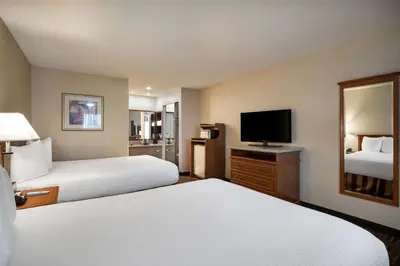 a hotel room with two beds and a flat screen tv at Best Western Norwalk Inn in Norwalk