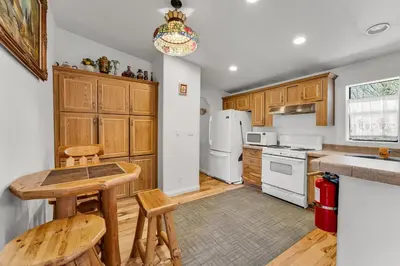 a kitchen with white appliances and wooden cabinets at Country Club Chalet in Big Bear City
