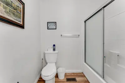 a white bathroom with a toilet and a shower at Country Club Chalet in Big Bear City