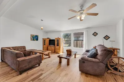 a living room with two couches and a ceiling fan at Country Club Chalet in Big Bear City