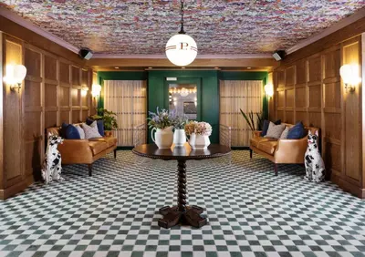 a lobby with couches and a table with flowers on it at Palihouse West Hollywood at Beverly Hills in Los Angeles