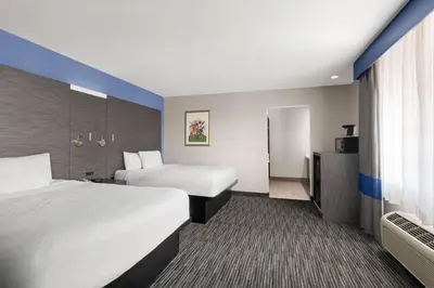 a hotel room with two beds and a bathroom at Travelodge Inn & Suites by Wyndham Anaheim on Disneyland Dr in Anaheim