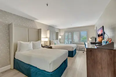 a hotel room with two beds and a television at Ocean View Hotel in Los Angeles