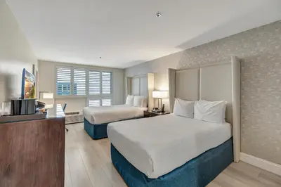 a hotel room with two beds and a television at Ocean View Hotel in Los Angeles