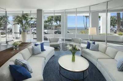 a living room with couches and a table with blue pillows at Ocean View Hotel in Los Angeles