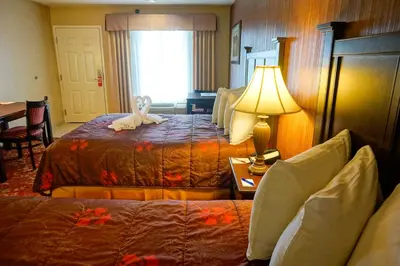 a hotel room with two beds with a stuffed animal on the bed at Castle Inn and Suites Anaheim in Anaheim