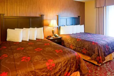 a hotel room with two beds and a telephone at Castle Inn and Suites Anaheim in Anaheim