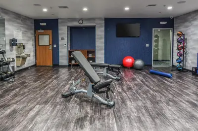 a room with a gym with a chair and weights at Fairfield Inn & Suites Ontario Rancho Cucamonga in Rancho Cucamonga