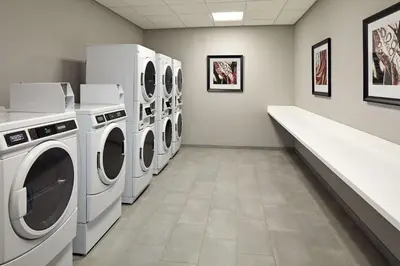 a laundry room with four washer and dryer machines at Hampton Inn Long Beach Airport, Ca in Long Beach