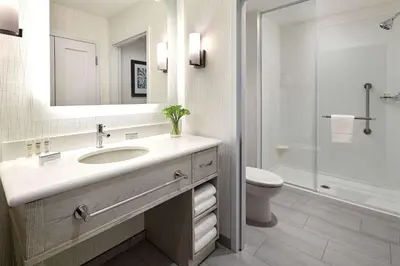 a bathroom with a sink and a toilet and a mirror at Homewood Suites By Hilton Long Beach Airport in Long Beach