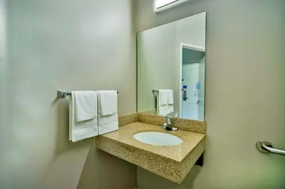 a bathroom with a sink with a mirror and towels at Studio 6-Bakersfield, CA in Bakersfield