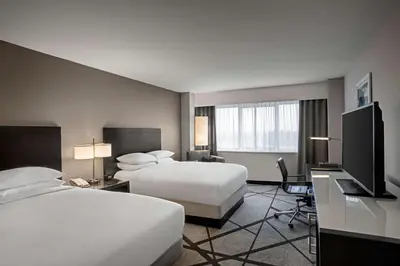 a hotel room with two beds and a flat screen tv at DoubleTree by Hilton Los Angeles Norwalk in Norwalk