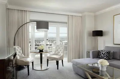 a living room with a couch and a table and chairs at Four Seasons Hotel Los Angeles at Beverly Hills in Los Angeles