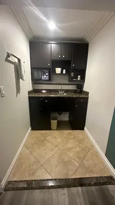 a kitchen with a sink and a counter in a room at Garden Inn and Suites Glendora in Glendora