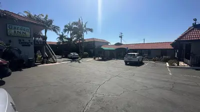 a car parked in a parking lot next to a building at Garden Inn and Suites Glendora in Glendora