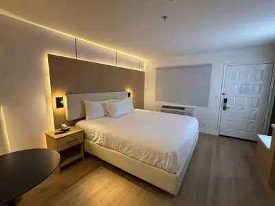 a bedroom with a large white bed and a table at MainStay Suites Victorville - Hesperia in Victorville